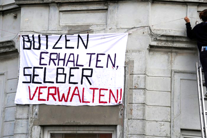 Ein Transparent an einer Hauswand: Butzen erhalten, selber verwalten